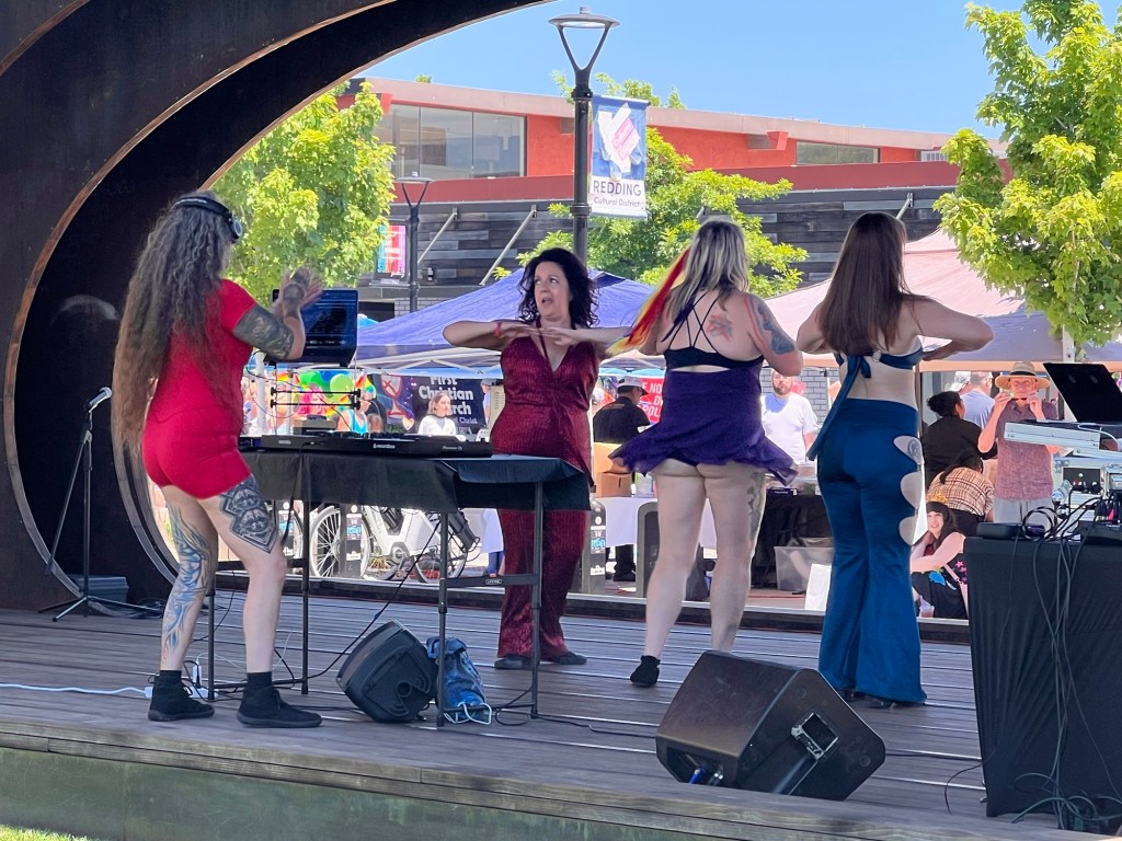 Dancers and dj on outdoor amphitheater stage at Pride
